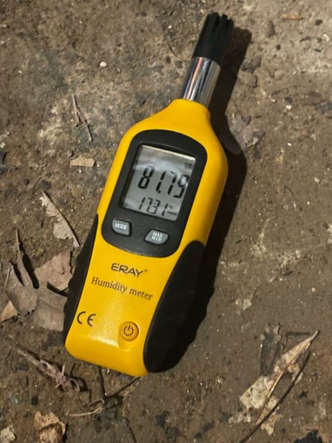 Moisture meter reading 81% humidity on the dirt floor of a damp Atlanta crawl space